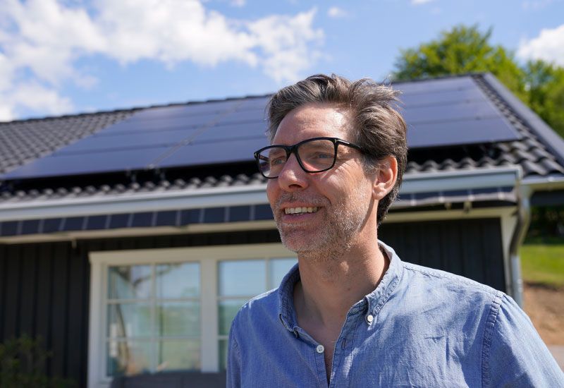 Man framför villa med solceller
