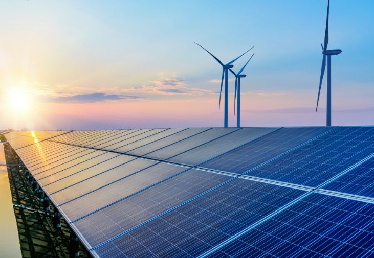 Vindkraftverk i bakgrunden med solpaneler i förgrunden