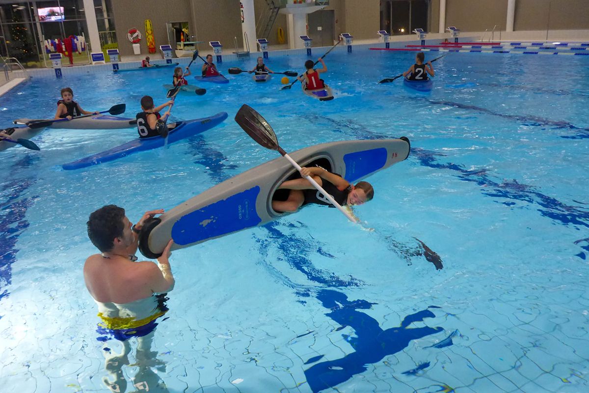 Roddare övar på att vända kajak i badhus