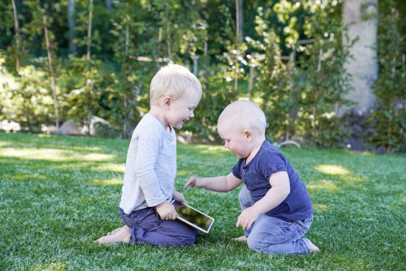 2 glada barn som skrattar och pekar på en iPad