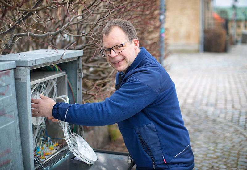 Man monterar fiber i skåp på gata
