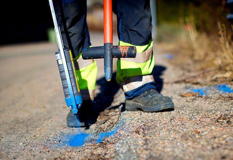 Installatör av fiber märker ut i gatan var det ska grävas