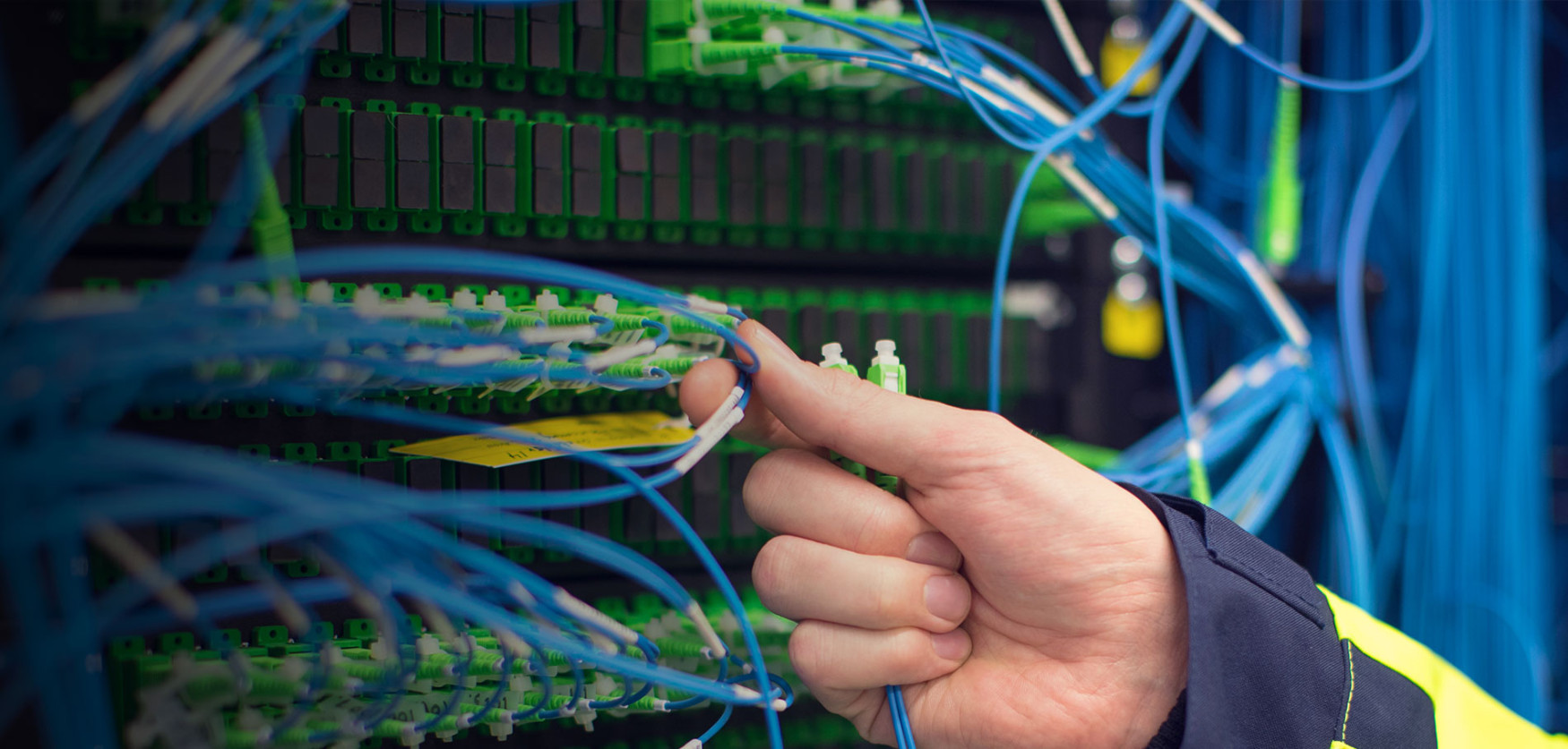 Hand som kontrollerar fiberanslutning i switch