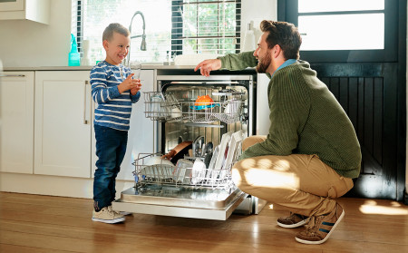 Pappa och son vid diskmaskin